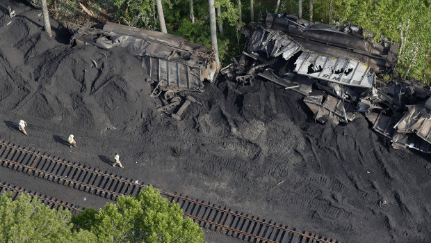 Workers are seen around the site after 36 railroad cars containing 3600 tonnes of coal derailed in the Great Dismal Swamp  in Virginia.
