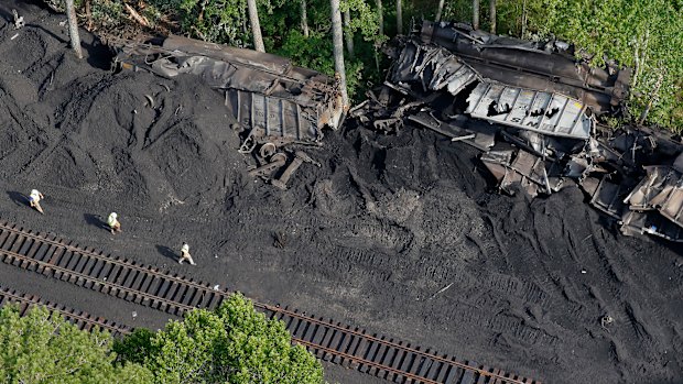 Workers are seen around the site after 36 railroad cars containing 3600 tonnes of coal derailed in the Great Dismal Swamp  in Virginia.