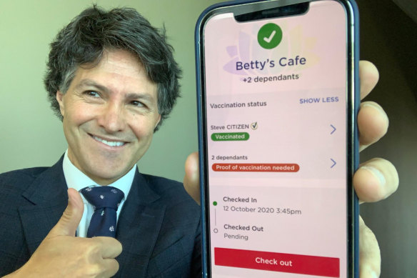 Customer Service Minister Victor Dominello with an iPhone displaying the Service NSW check-in app.
