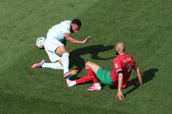 Morocco’s Noussair Mazraoui commits a penalty as he tackles Kylian Mbappe.