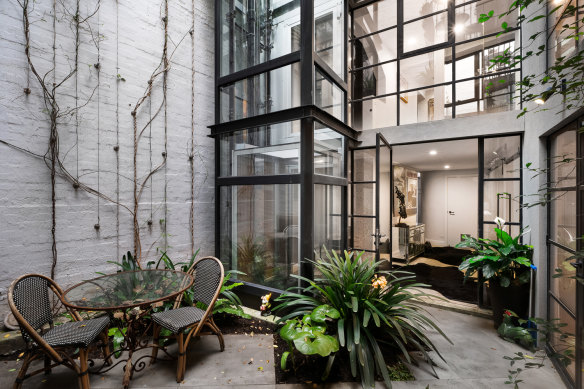 A multi-level warehouse-style apartment in South Yarra, designed by architect Daryl Jackson, thoughtfully integrated the glass-sided lift into the fabric of the building.