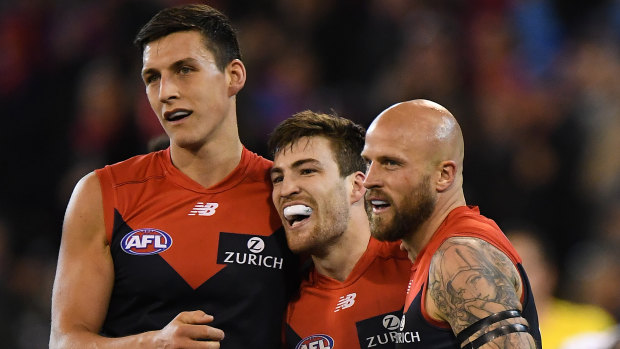 In with a shout: Jack Viney, centre, and Demons teammates.