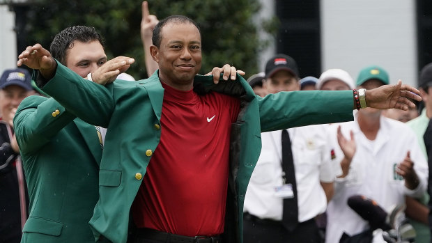 Tiger Woods dons the famous green jacket after his long-awaited victory at the US Masters on Monday.