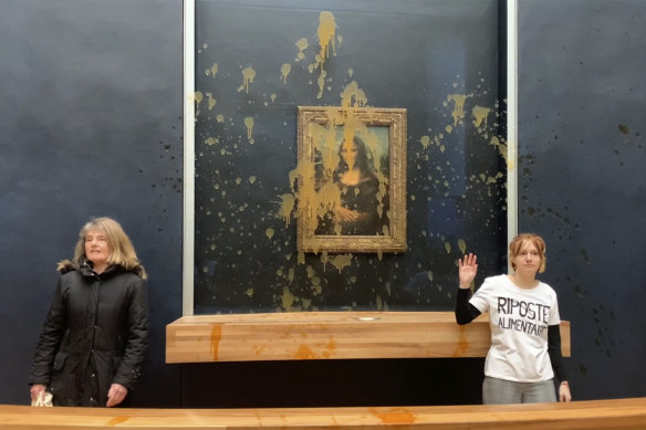 Activists standing by their work in the Louvre.