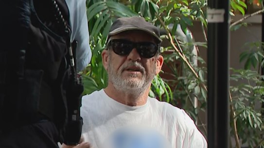 Police outside the building holding the Royal Commission into Antisemitism and Social Cohesion in the Sydney CBD speak to a man wearing an antisemitic T-shirt.