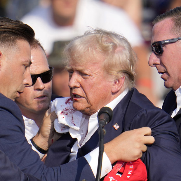 A bloodied Donald Trump helped off the stage at the campaign event in Butler.