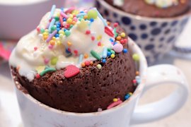Molten chocolate mug cake with ice-cream and sprinkles.