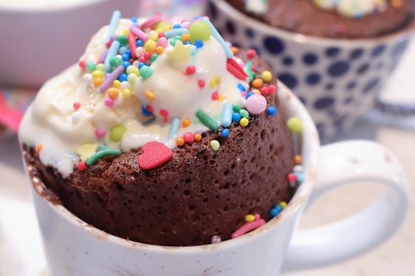 Molten chocolate mug cake with ice-cream and sprinkles.