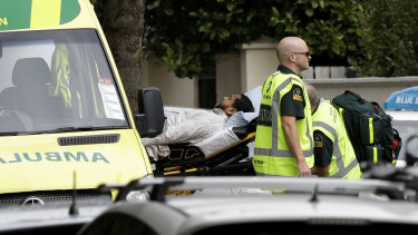 Ambulance staff take a man from outside a mosque in central Christchurch following a mass shooting.