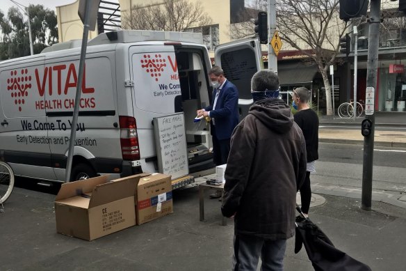 Ricky Nixon on Bay Street in Port Melbourne in 2020 selling PPE alongside his health company van. 