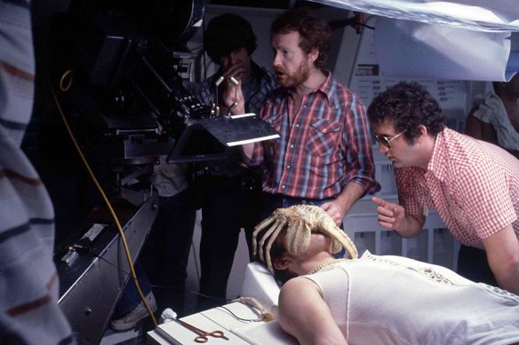 Ridley Scott (with beard) directs a scene featuring the creature in "facehugger" form.