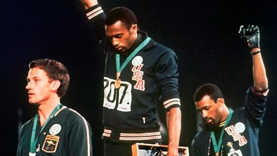 American athletes Tommie Smith, centre, and John Carlos extended gloved hands in a protest at the Mexico City Games in 1968. Silver medallist Australia’s Peter Norman stands on the left. He wore a badge supporting the “Olympic Project for Human Rights”.