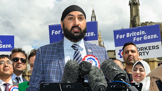 Leader of the Workers Party of Britain George Galloway (right) looks on as former England cricketer Monty Panesar (centre) addresses fellow party candidates in Parliament Square.
