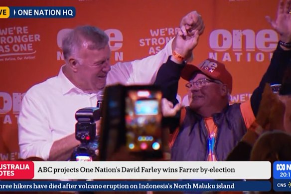Newly elected One Nation candidate David Farley invites volunteer Allan Beale onstage during victory speech. 