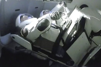 NASA astronauts Doug Hurley and Robert Behnken aboard the SpaceX Dragon crew capsule as it docks with the International Space Station.