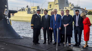 French President Emmanuel Macron and Australian government members at Garden Island last year. The new submarine program has led to stronger French-Australian relations - but cultural differences are emerging.