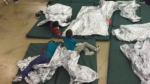 Children who have been taken into custody related to cases of illegal entry into the United States, rest in one of the cages at a facility in McAllen, Texas. 