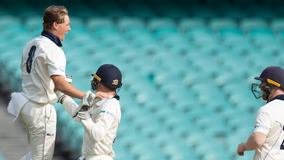 Victoria's Wil Parker, left, celebrates after taking the wicket of Moises Henriques on day two. 