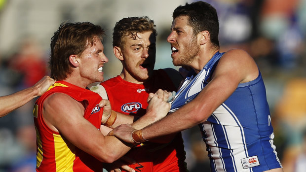 Gold Coast pair Noah Anderson and Hugh Greenwood remonstrate with North Melbourne’s Tristan Xerri.