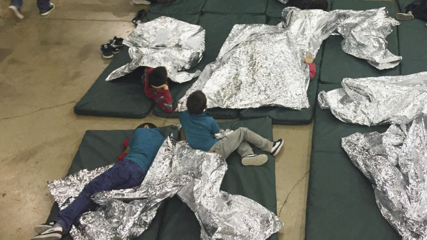 People who have been taken into custody related to cases of illegal entry into the United States, rest in one of the cages at a facility in McAllen, Texas. 