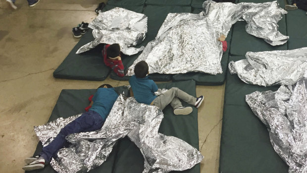 Children who have been taken into custody related to cases of illegal entry into the United States, rest in one of the cages at a facility in McAllen, Texas. 