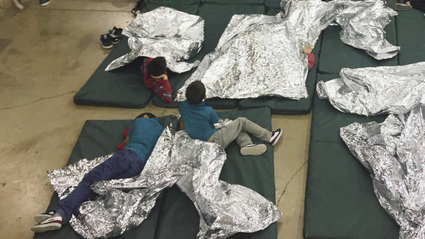 Teens taken into custody on the US-Mexico border rest in one of the cages at a facility in McAllen, Texas.