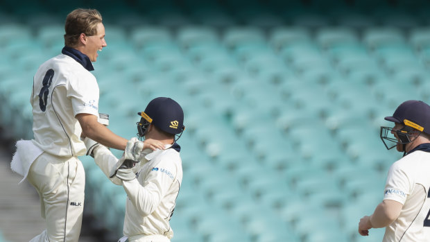 Victoria's Wil Parker, left, celebrates after taking the wicket of Moises Henriques on day two. 
