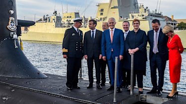 French President Emmanuel Macron and Australian government members at Garden Island last year. The new submarine program has led to stronger French-Australian relations - but cultural differences are emerging.