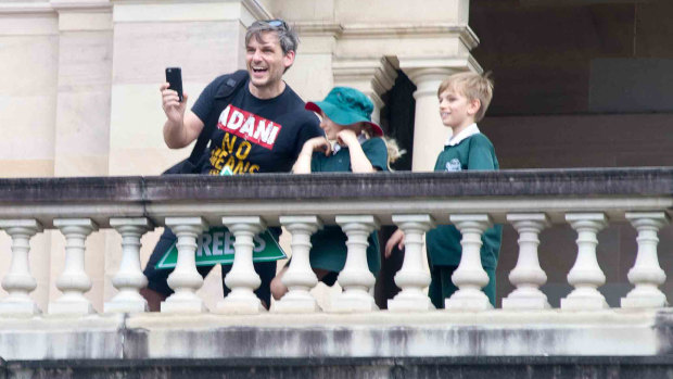 Queensland Greens MP Michael Berkman on the balcony in Parliament while wearing an anti-Adani T-shirt.