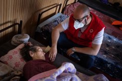 Albert Gomez, a doctor from the Spanish Red Cross, comforts an elderly refugee who fled her home in Ukraine.