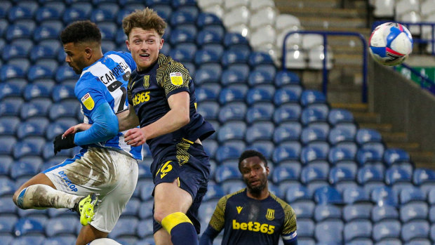 Harry Souttar wins an aerial battle against Huddersfield Town’s Fraizer Campbell.