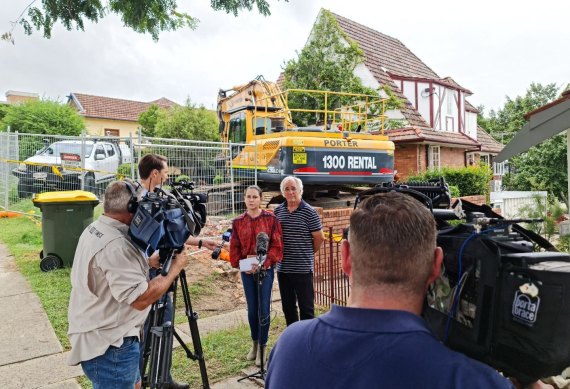 Toowong residents John Scott and Freya Robertson express their concerns as bulldozers remove Linden Lea at Toowong.