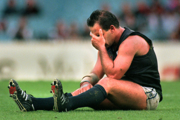 Greg Williams sits stunned on the ground after being hit in a match against Essendon.