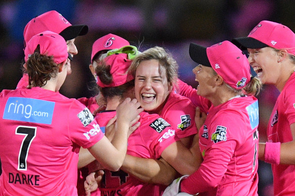 Ellyse Perry, centre, celebrates with her Sixers teammates after taking the wicket of Rachel Priest.