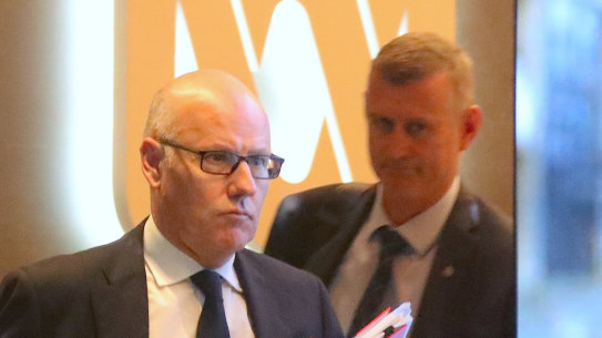 The ABC's executive editor John Lyons is followed by an AFP officer during Wednesday's raids.