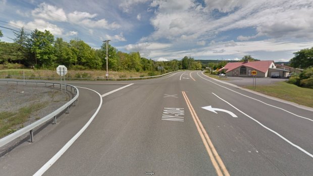 Route 30 leads steeply downhill to a T-intersection with Route 30A, marked with a stop sign. The Apple Barrel Country Store is on the right.