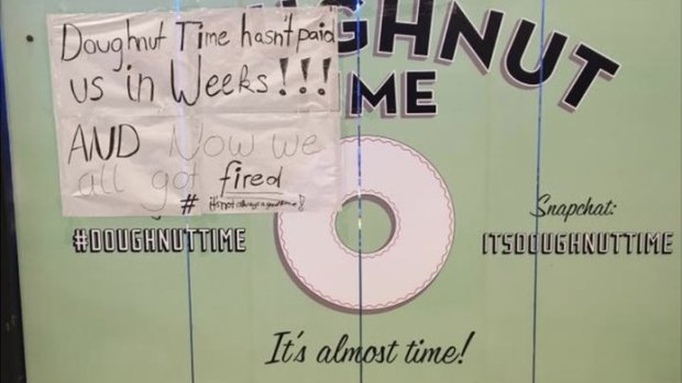 A handwritten sign on the wall of the Doughnut Time store at Sydney\'s Queen Victoria Building displays worker anger.