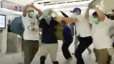 Masked men attack people at Yuen Long metro station.