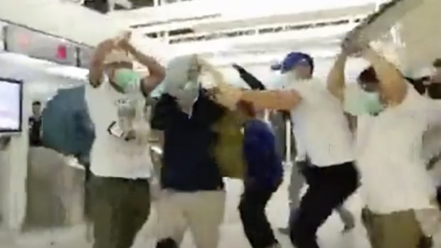 Masked men attack people at Yuen Long metro station in July 2019.