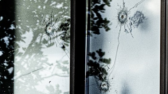 Bullet holes on the upper storey windown and balcony of the home