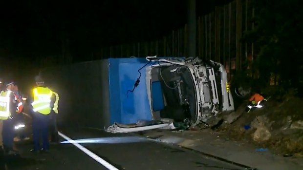 A driver was freed after a truck rolled on its side on its motorway, but another man died at a crash scene 50 metres down the road.