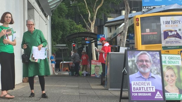 Volunteers armed with how-to-vote cards outside the Brisbane City early voting centre on Queen Street on Friday.