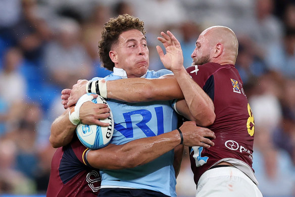 Mark Nawaqanitawase of the Waratahs is tackled during the round three Super Rugby Pacific match against the Highlanders