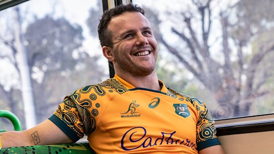 Dylan Pietsch posing in Wallabies kit on a Melbourne tram in 2023, while in the Australian squad.