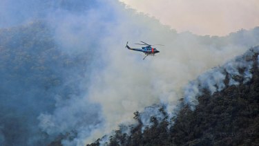 A helicopter waterbombing fires on NSW's south coast in mid-August.