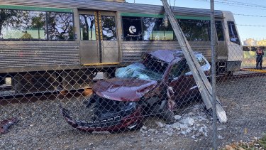The car was parked on the train line near the railway crossing point. 