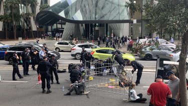 Extinction Rebellion activists block traffic at the intersection of Eagle Street and Creek Street by locking themselves to metal barricades.