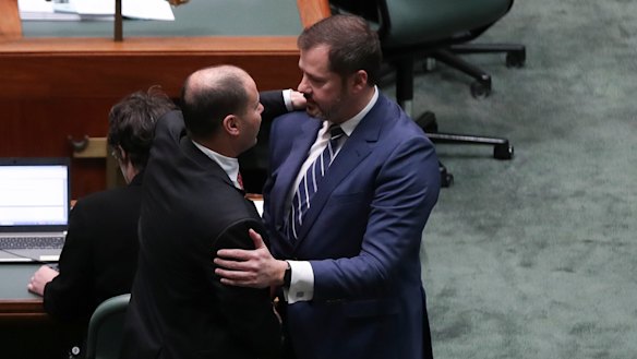 Josh Frydenberg and Ed Husic embrace on the floor of Parliament after condemning a divisive speech given by Fraser Anning.