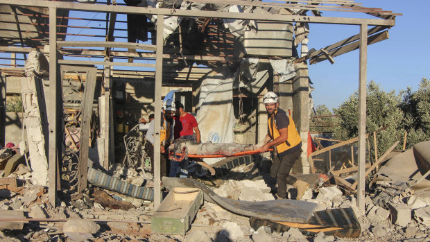 This photo released by the Syrian Civil Defence White Helmets in Daraa, shows civil defence workers carrying a victim from a house, after shelling by Syrian government forces, in the town of Nawa, Daraa, southern Syria.