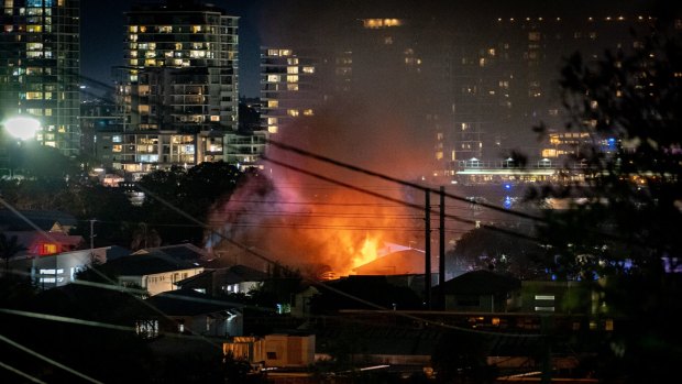 Flames visible on the Brisbane CBD skyline as the Bulimba home burns on Sunday.